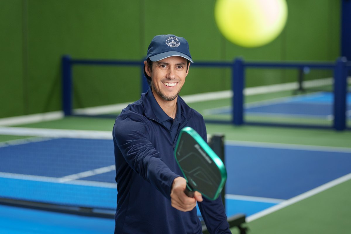 A certified ELEVENO pro on court with a paddle, ready to run a drill