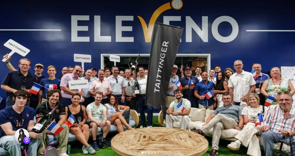 A large group gathered under the ELEVENO sign at a Champagne Taittinger evening