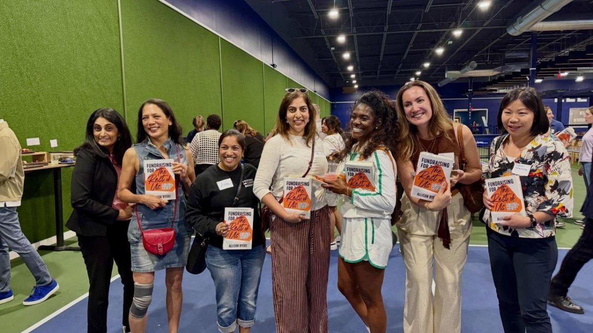 Guests holding books at a launch party on the ELEVENO courts